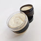 Angled aerial view of the 4oz and 8oz Shea Butter containers are stacked on the 8oz lid.