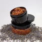 A 4oz Rosé Marmalade Scrub stacked on an 8oz container of the product. Lavender petals are scatters all around the product.